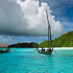 **

A panoramic view of Palau's Rock Islands, showcasing their unique mushroom-like shapes and vibrant turquoise waters. In the background, subtle storm clouds hint at the climate change challenges faced by the island nation. In the foreground, a traditional Palauan outrigger canoe glides through the water, symbolizing the blend of tradition and resilience. Capture the beauty and vulnerability of Palau's natural landscape.

**