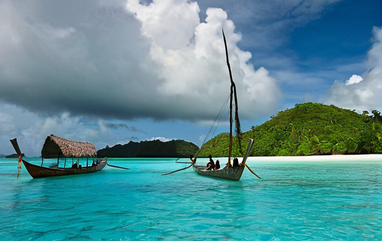 **
A panoramic view of Palau's Rock Islands, showcasing their unique mushroom-like shapes and vibrant turquoise waters. In the background, subtle storm clouds hint at the climate change challenges faced by the island nation. In the foreground, a traditional Palauan outrigger canoe glides through the water, symbolizing the blend of tradition and resilience. Capture the beauty and vulnerability of Palau's natural landscape.
**
